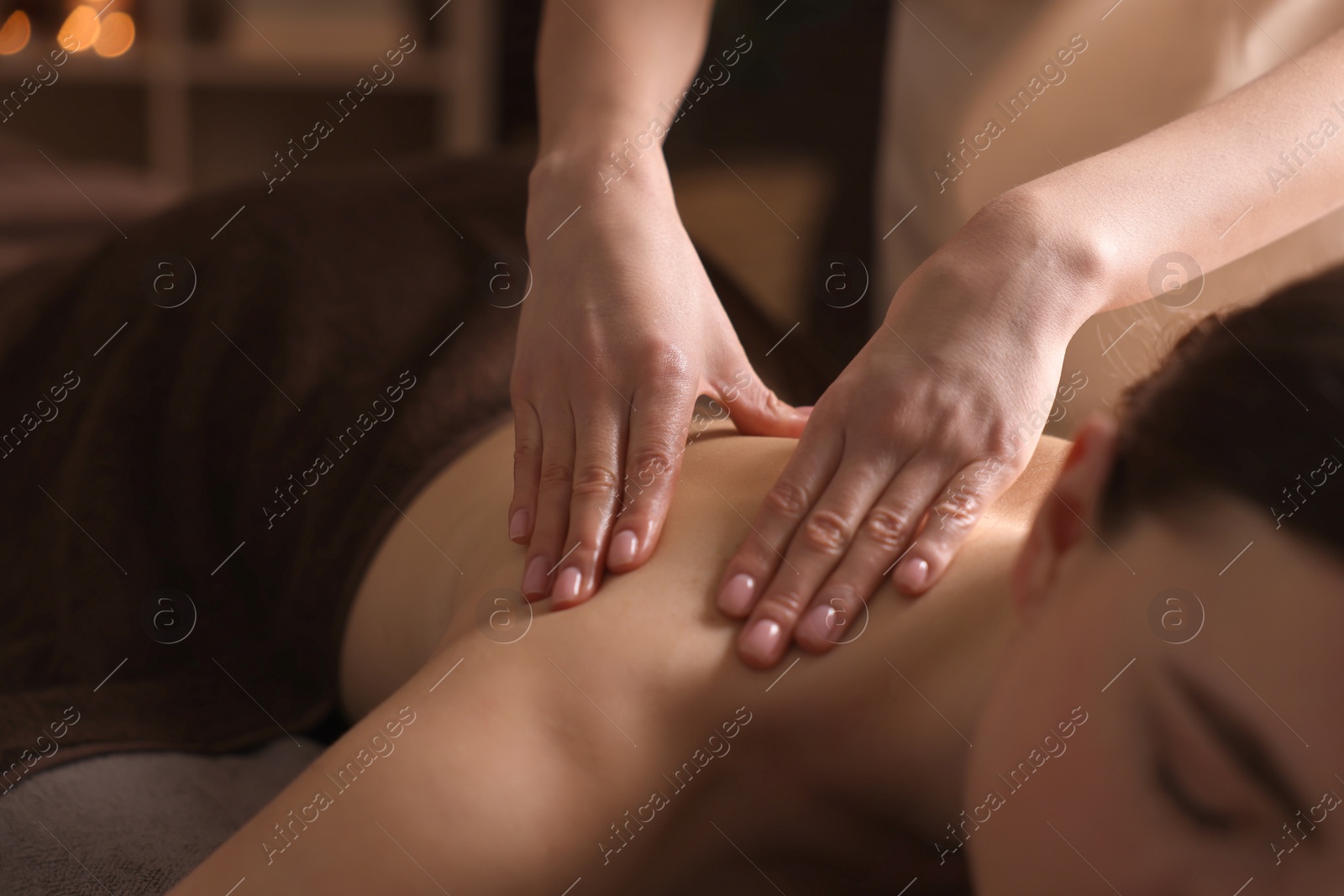 Photo of Spa therapy. Beautiful young woman lying on table during massage in salon, closeup