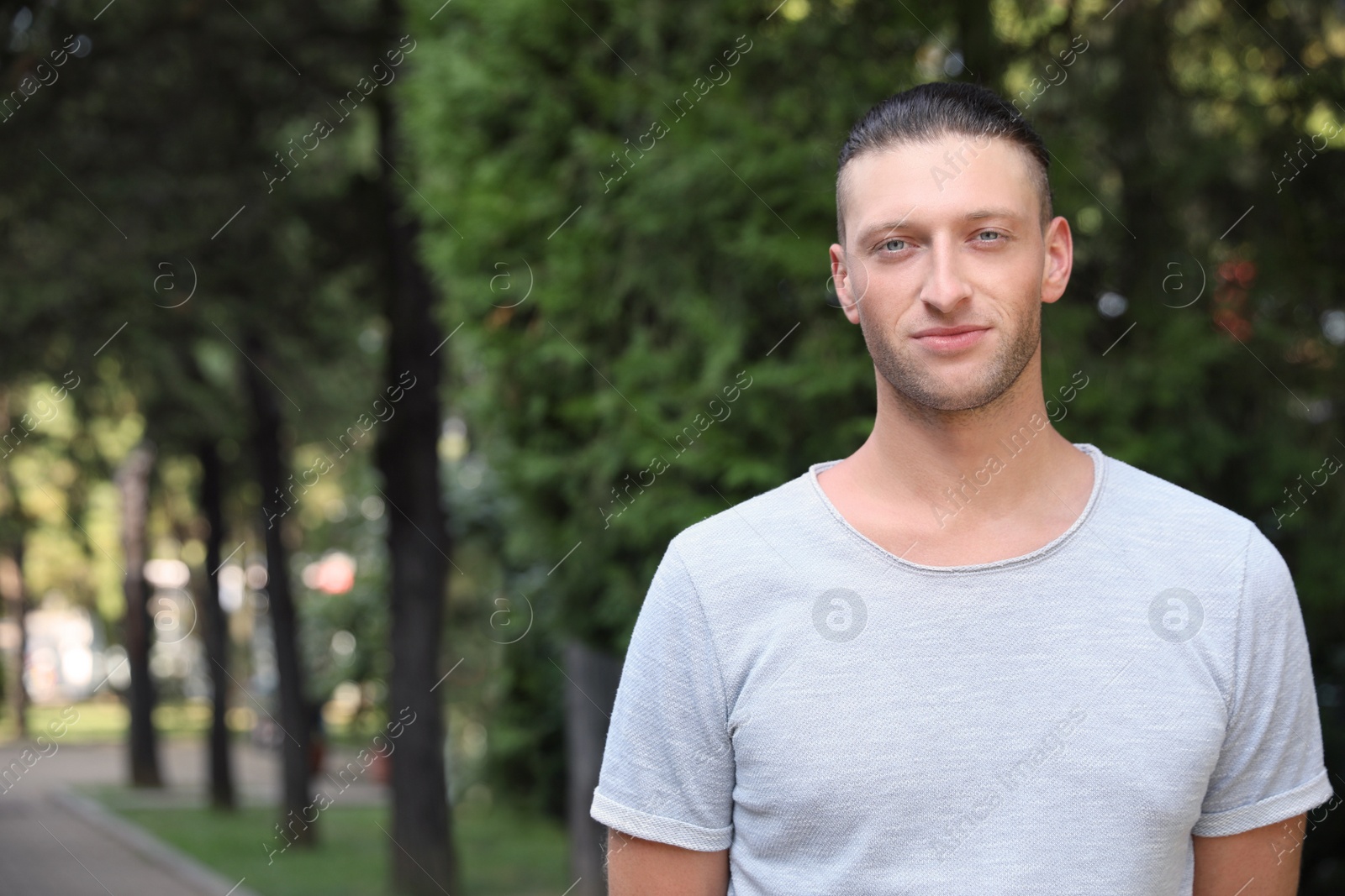 Photo of Portrait of handsome young man in park, space for text