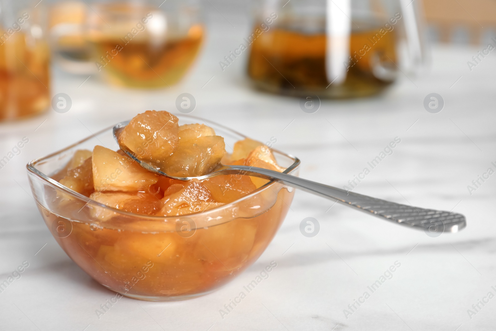 Photo of Delicious apple jam in bowl on white table, closeup