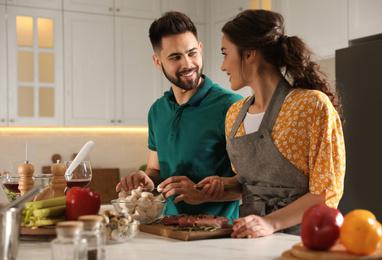 Photo of Lovely young couple cooking together in kitchen