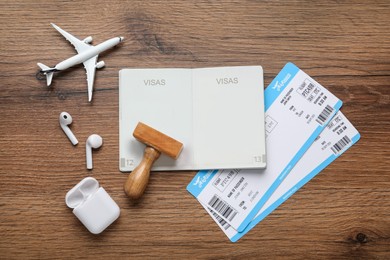 Flat lay composition with passport, stamp and flight tickets on wooden table