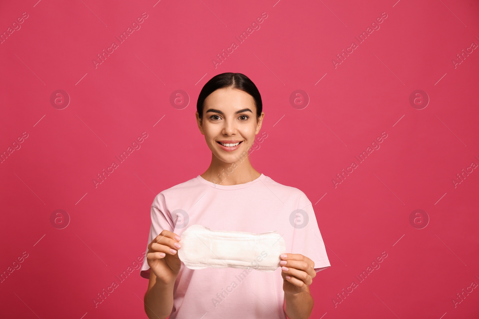 Photo of Young woman with menstrual pad on bright pink background