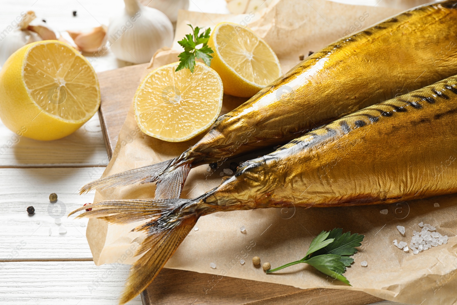 Photo of Tasty smoked fish on white wooden table, closeup