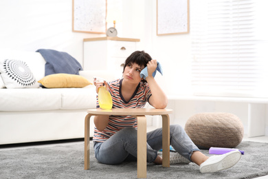 Lazy woman procrastinating while cleaning at home