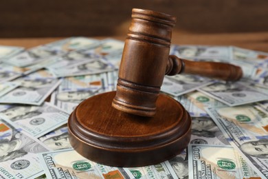 Photo of Judge's gavel and money on wooden table, closeup