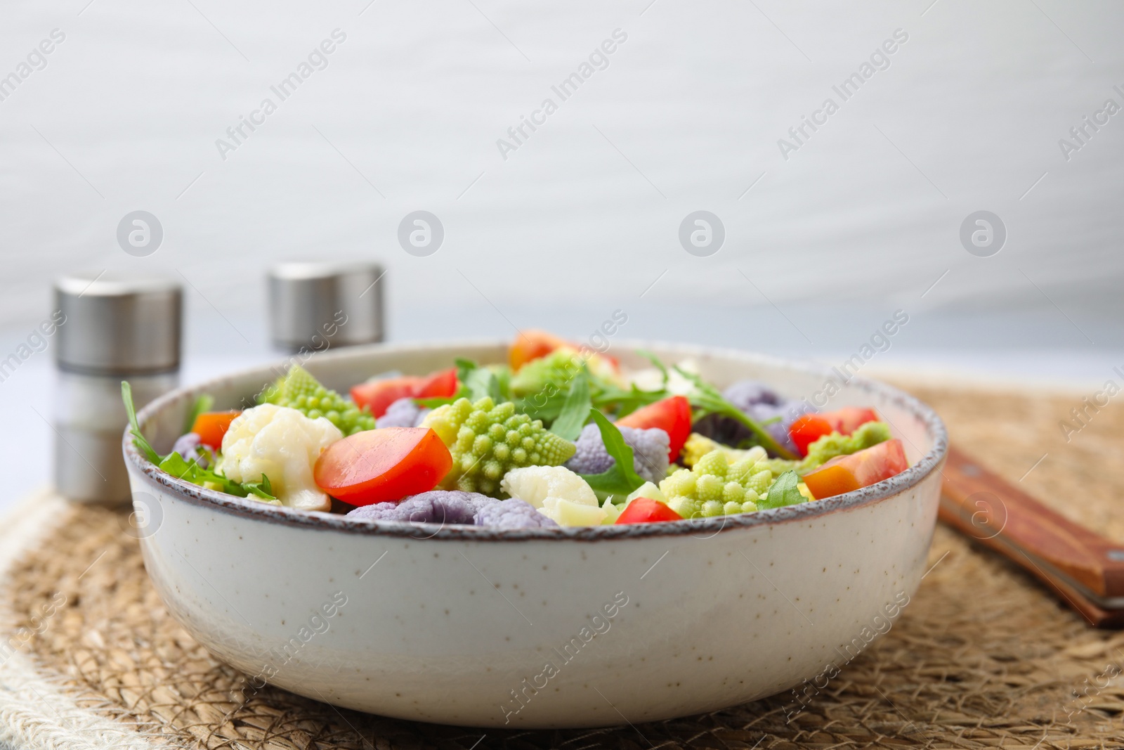 Photo of Delicious salad with cauliflower and tomato served on table, closeup