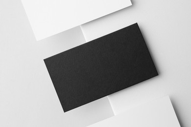 Blank black and white business cards on light background, flat lay. Mockup for design