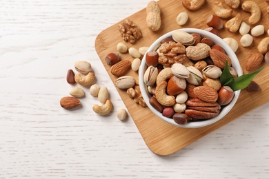 Photo of Bowl with organic mixed nuts on table, top view