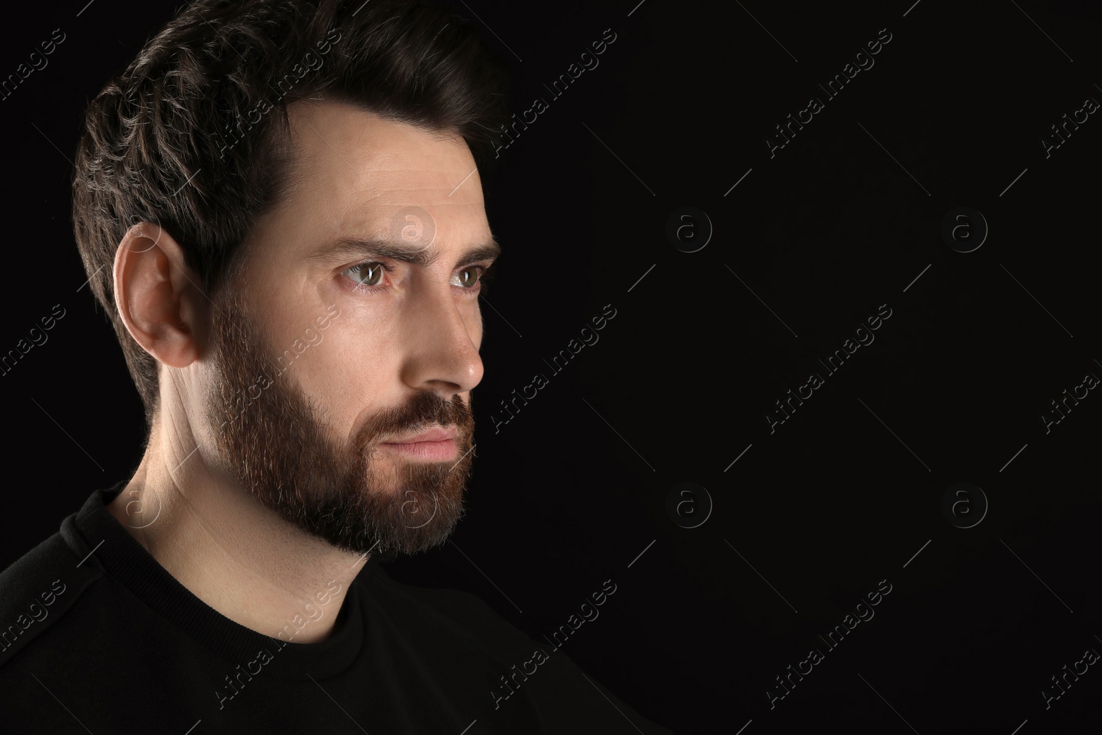 Photo of Evil eye. Man with scary eyes on black background, closeup and space for text