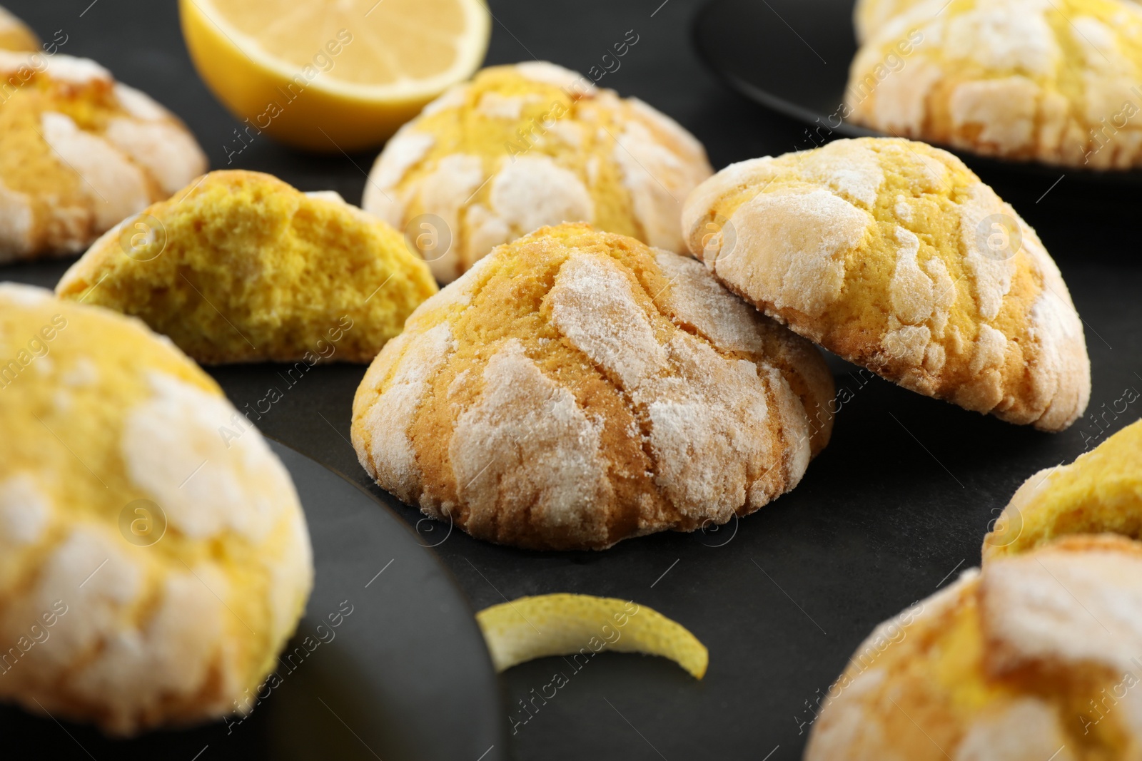 Photo of Delicious lemon cookies on black table, closeup