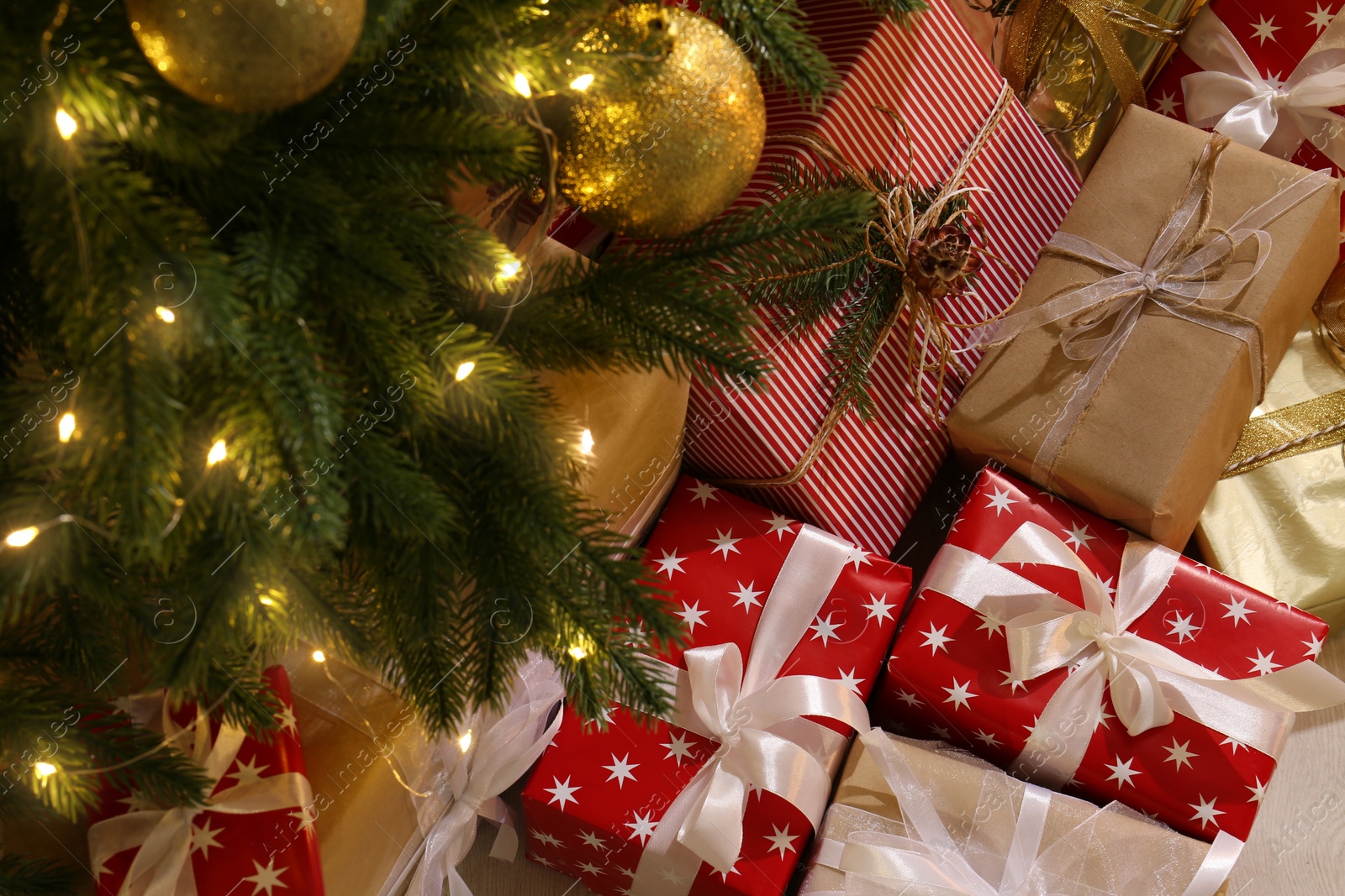 Photo of Gift boxes under Christmas tree with fairy lights