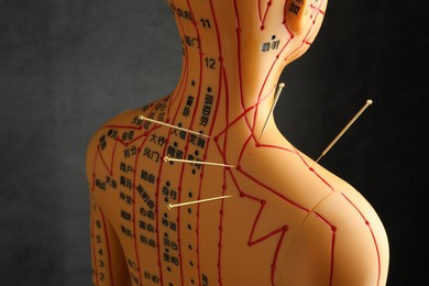 Photo of Acupuncture - alternative medicine. Human model with needles in shoulder against dark grey background