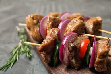 Photo of Roasted meat served with vegetables on wooden board, closeup