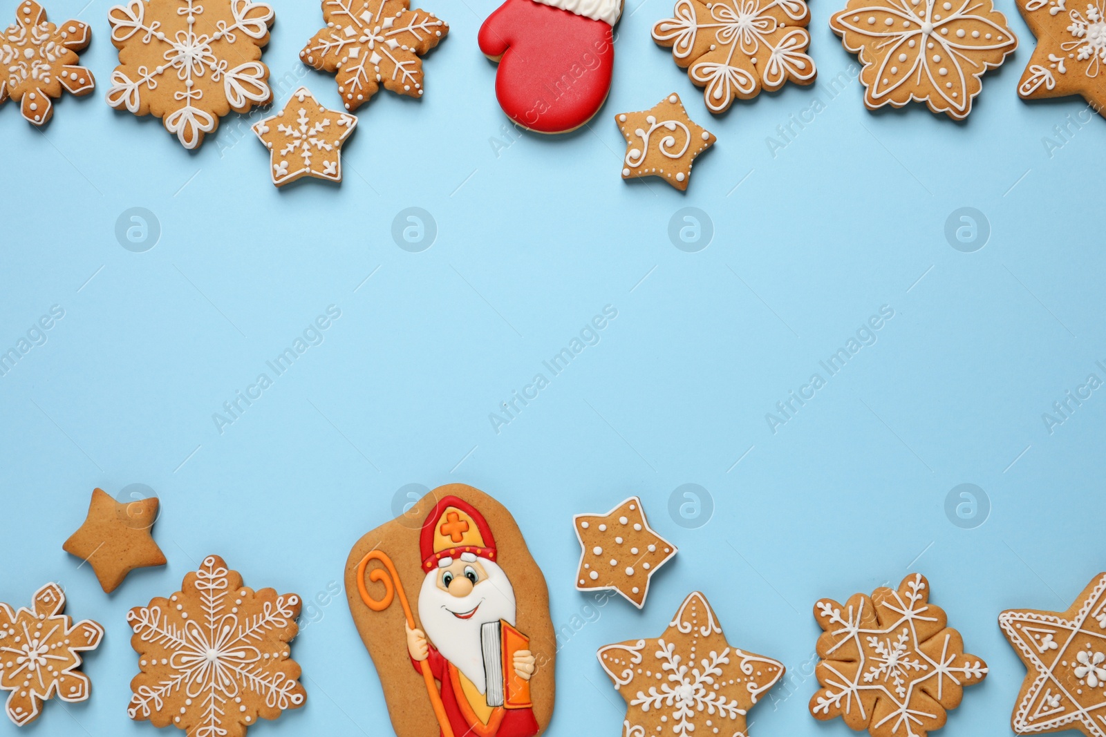 Photo of Frame of tasty gingerbread cookies on light blue background, flat lay with space for text. St. Nicholas Day celebration