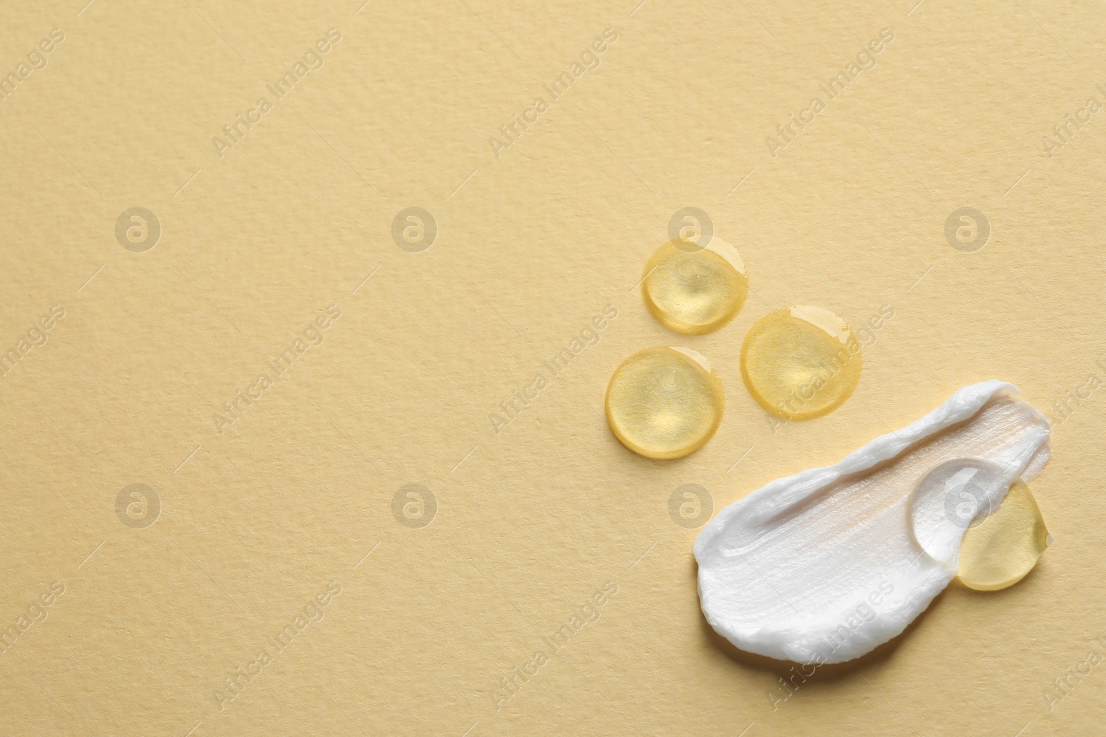 Photo of Samples of transparent gel and white cream on yellow background, flat lay. Space for text