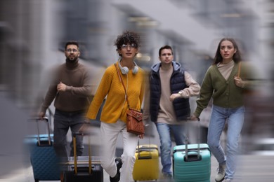 Image of Being late. Group of people with suitcases running outdoors. Motion blur effect