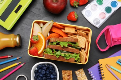 Photo of Flat lay composition with lunch box, tasty healthy food and school stationery on grey table