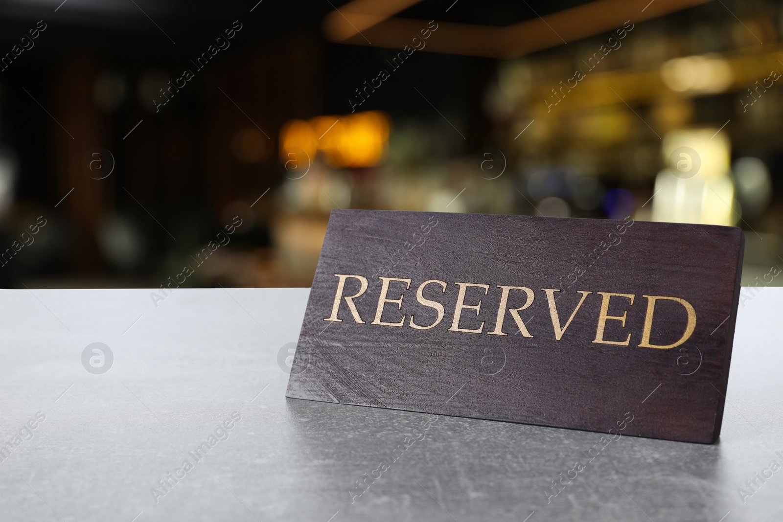 Image of Wooden sign Reserved on grey table in restaurant