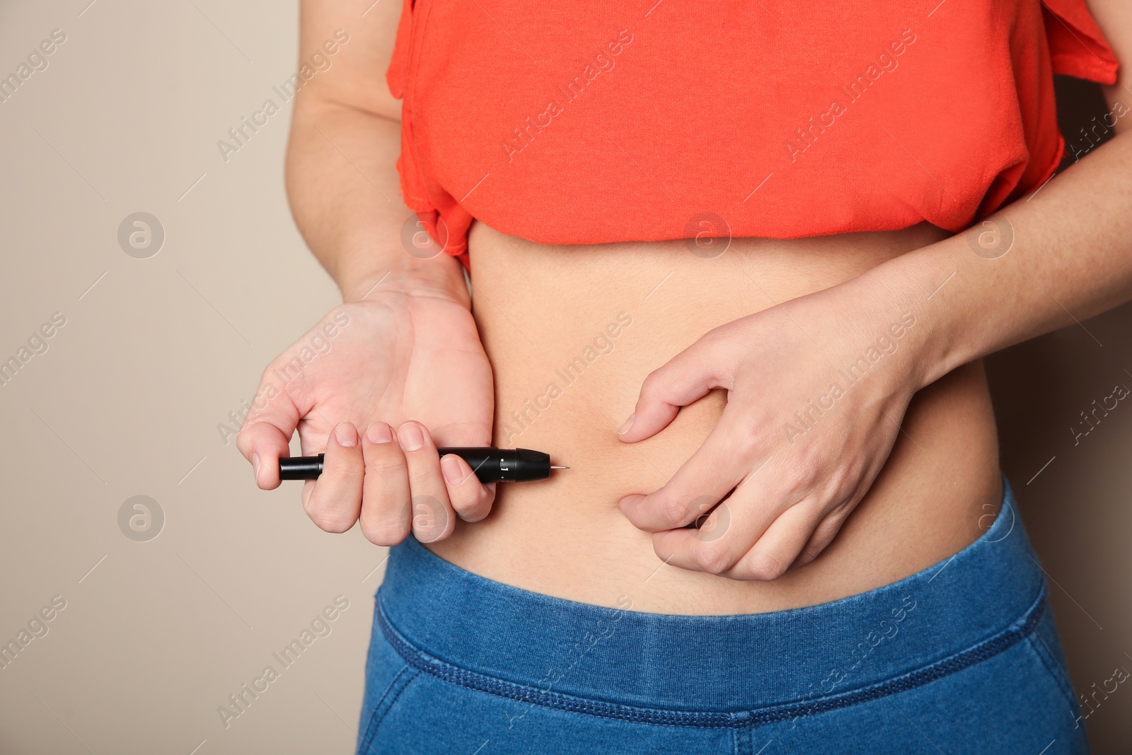 Photo of Woman doing insulin injection in stomach, closeup. Diabetes disease