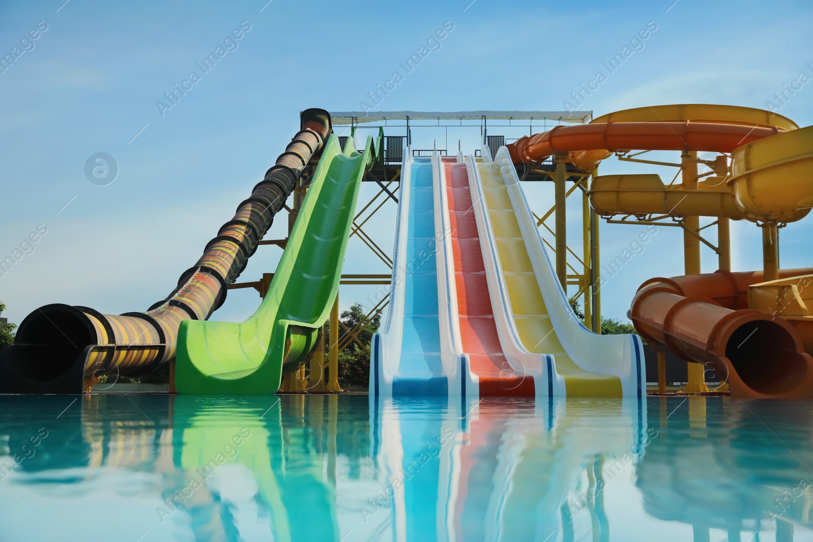 Photo of Beautiful view of water park with colorful slides and swimming pool on sunny day