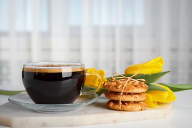 Photo of Aromatic morning coffee, cookies and beautiful flowers on white table