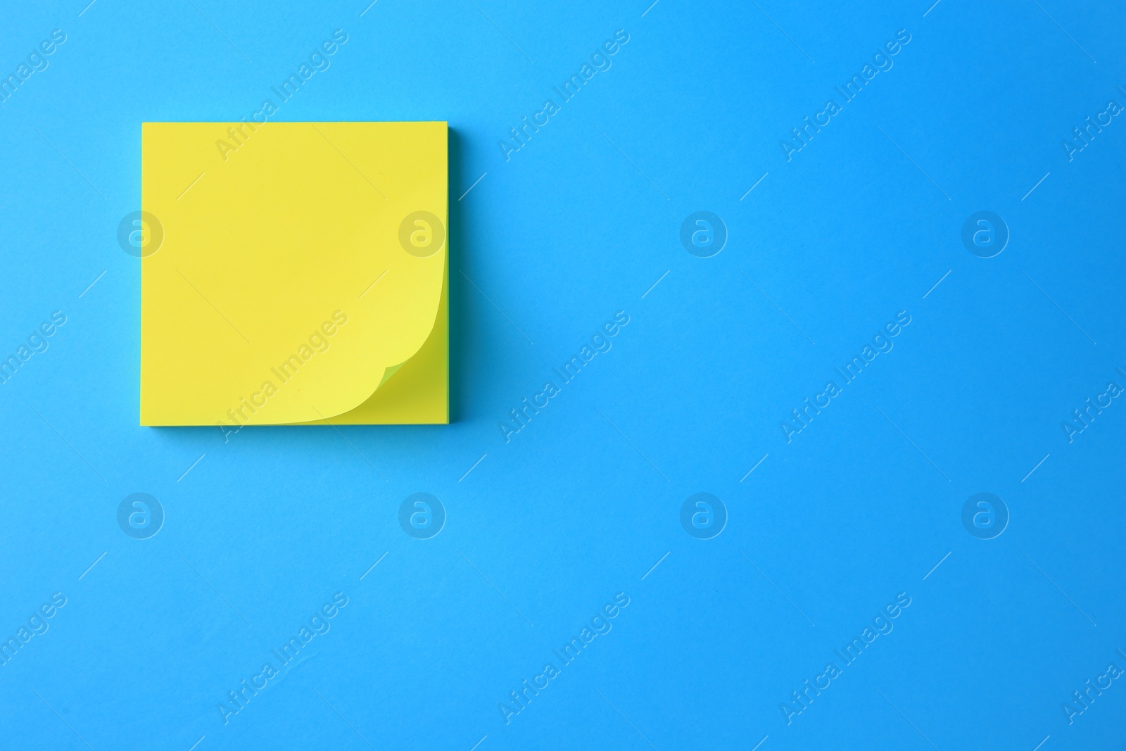 Photo of Blank paper note on light blue background, top view. Space for text