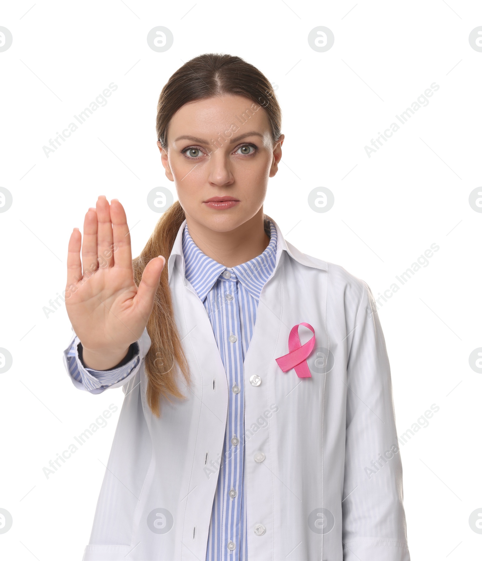 Photo of Mammologist with pink ribbon showing stop gesture against white background. Breast cancer awareness