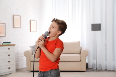 Cute boy singing in microphone at home