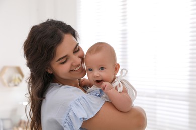 Photo of Happy young mother with her cute baby near window at home