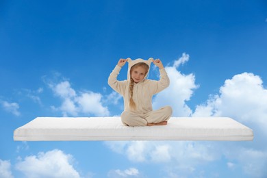 Healthy sleep. Little girl on comfortable mattress in blue sky