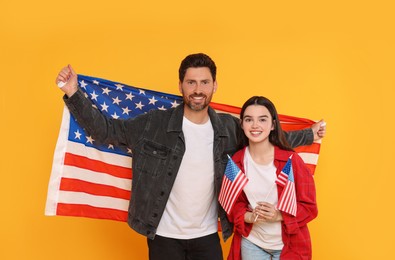 Photo of 4th of July - Independence Day of USA. Happy man and his daughter with American flags on yellow background