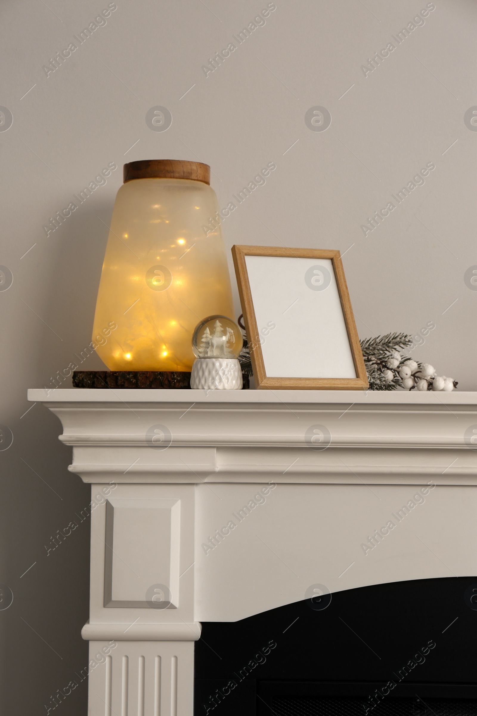 Photo of Stylish interior decorations on fireplace near white wall indoors