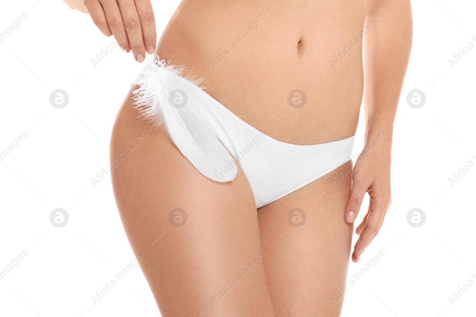 Photo of Woman with feather showing smooth skin on white background, closeup. Brazilian bikini epilation