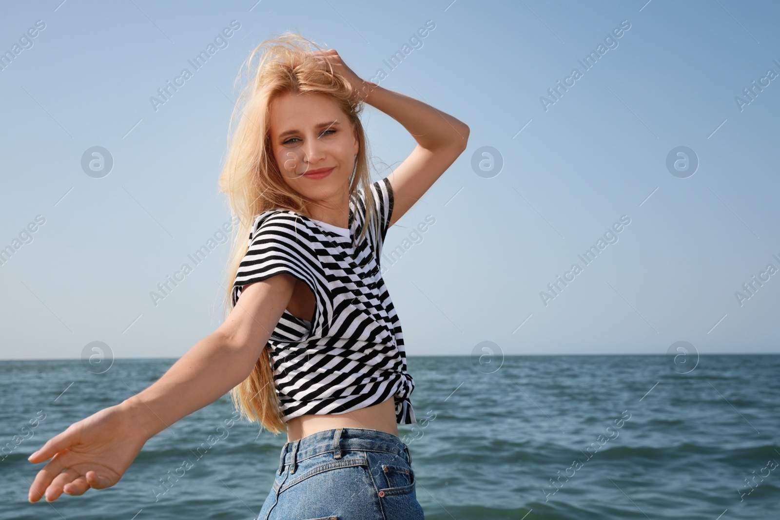 Photo of Beautiful young woman near sea on sunny day in summer