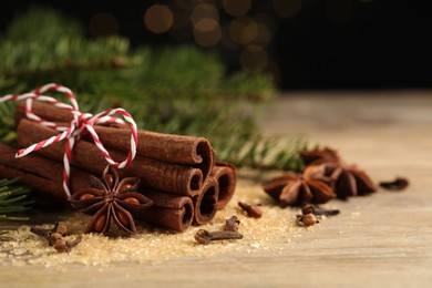 Photo of Different spices on wooden table, closeup. Space for text