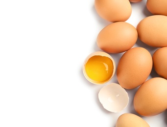 Photo of Cracked and whole chicken eggs on white background, top view