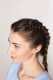 Woman with braided hair on light background