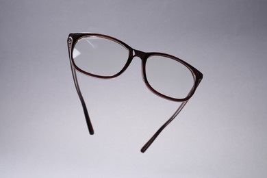Stylish pair of glasses on light grey background