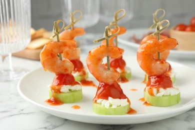 Photo of Tasty canapes with shrimps, vegetables and cream cheese on white marble table