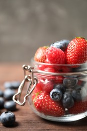 Photo of Mix of ripe berries on wooden table, closeup