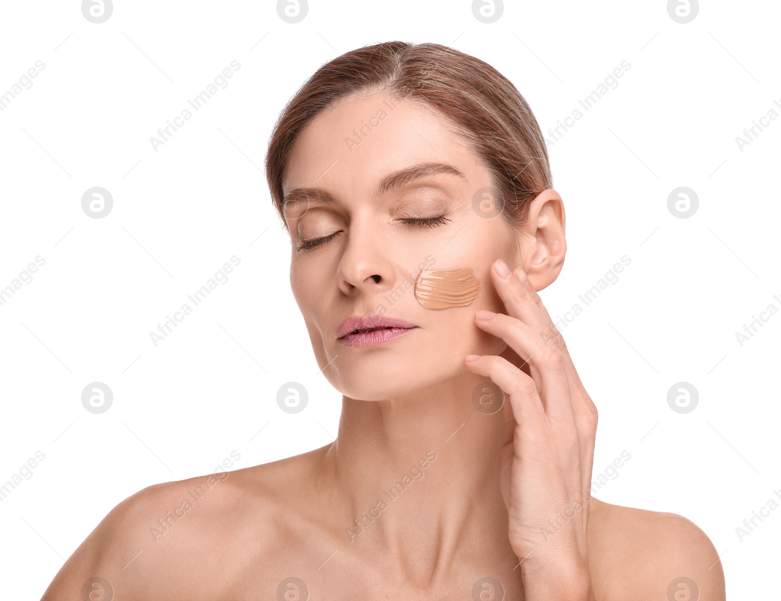 Photo of Woman with swatch of foundation on face against white background