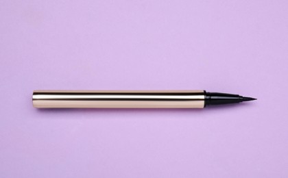 Eyeliner marker on lilac background, top view. Makeup product