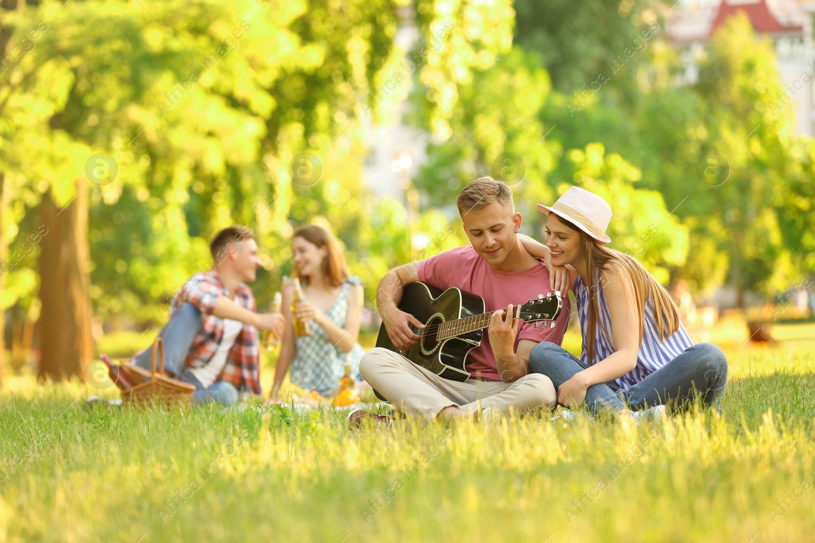 Photo of Young people enjoying picnic in park on summer day