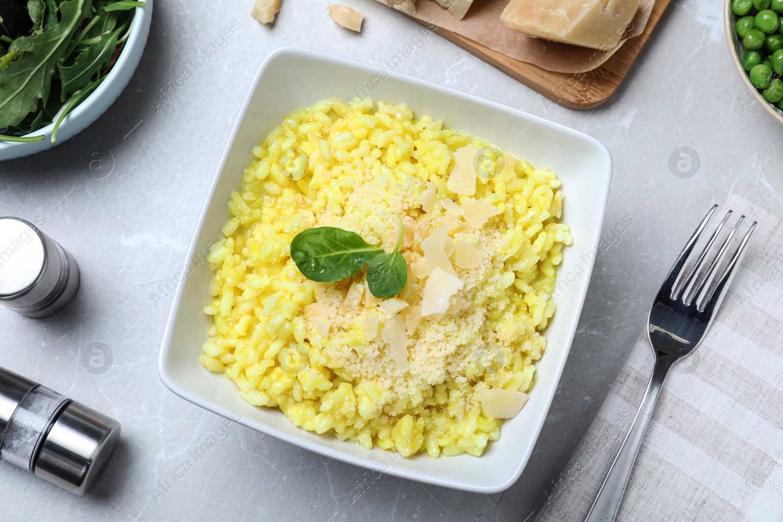 Photo of Delicious risotto with cheese on grey marble table, flat lay