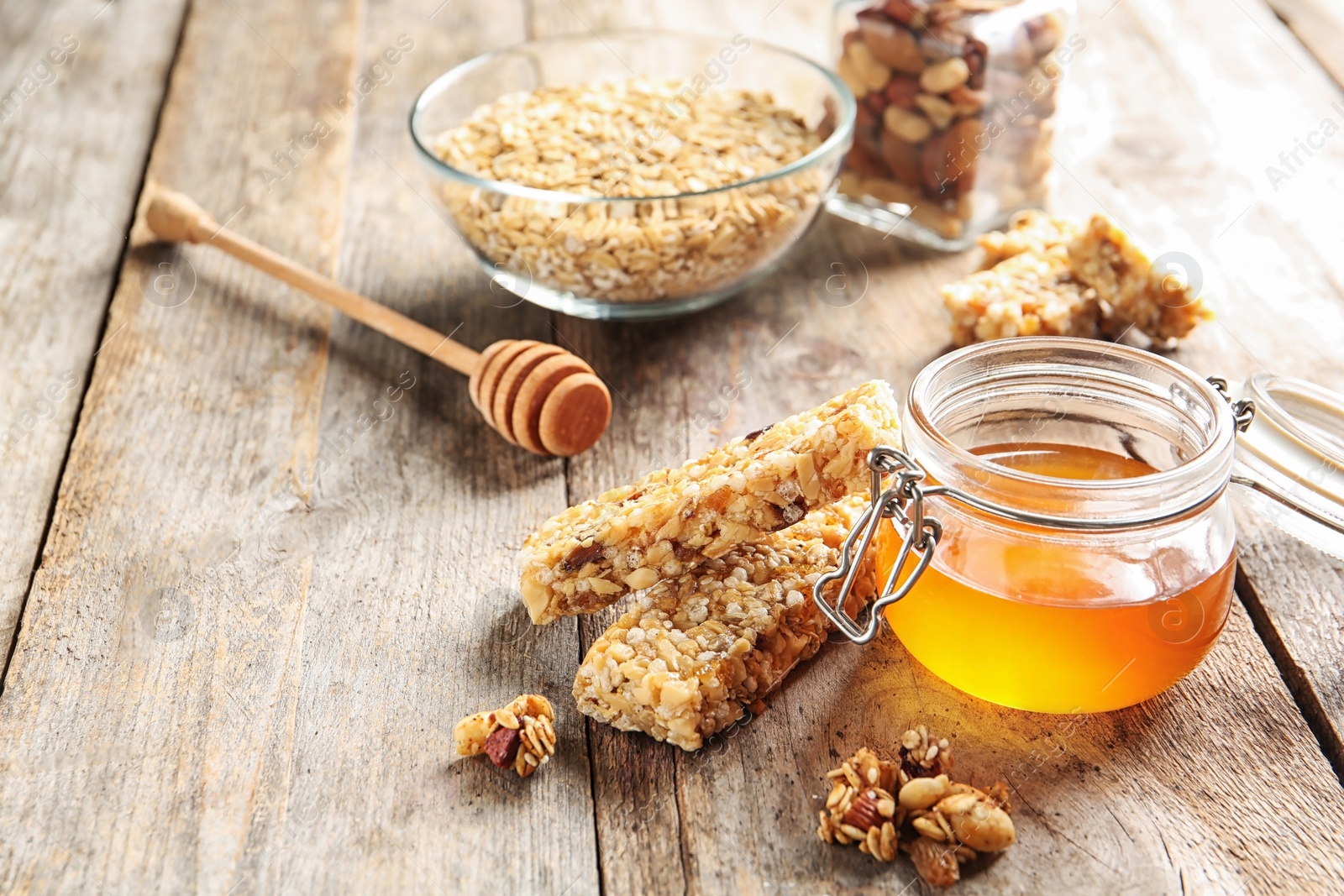 Photo of Homemade grain cereal bars and honey on wooden table. Healthy snack