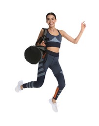 Beautiful woman with sports bag jumping on white background