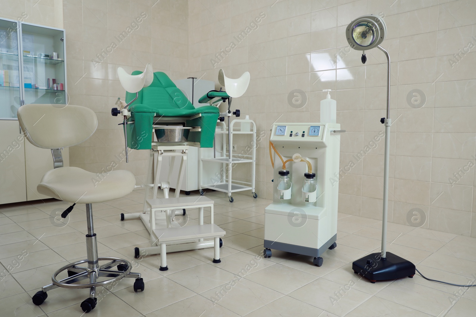 Photo of Examination room with gynecological chair and medical equipment in clinic