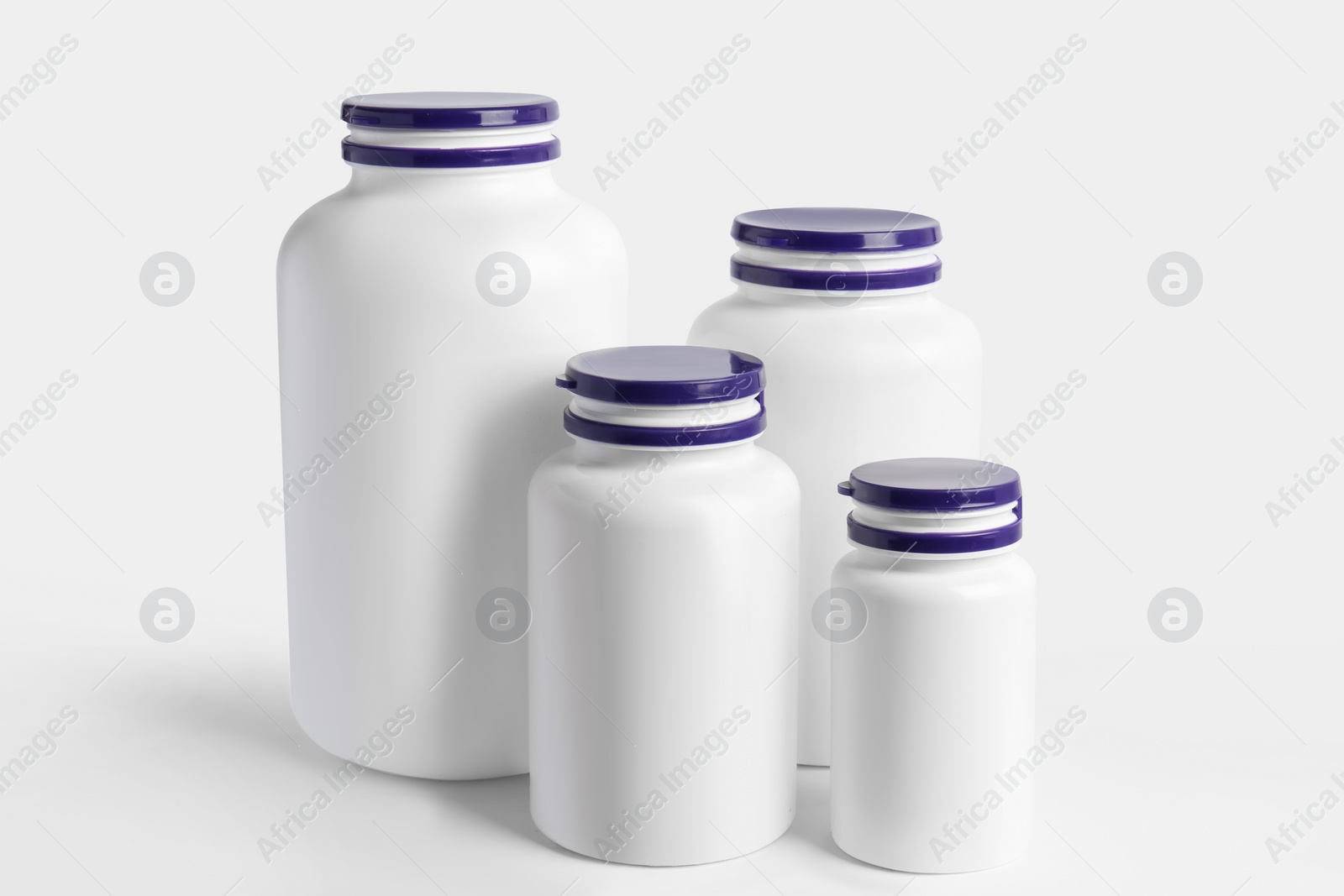 Photo of Different plastic medicine bottles on white background. Medicament