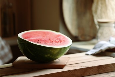 Photo of Half of fresh juicy watermelon on wooden table. Space for text