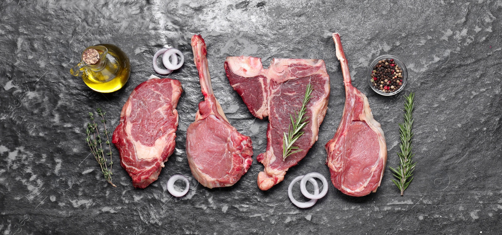 Photo of Fresh raw beef cuts and different spices on grey textured table, flat lay